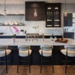 Modern kitchen with marble island and stools.