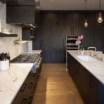 Modern kitchen with dark cabinets and countertops.